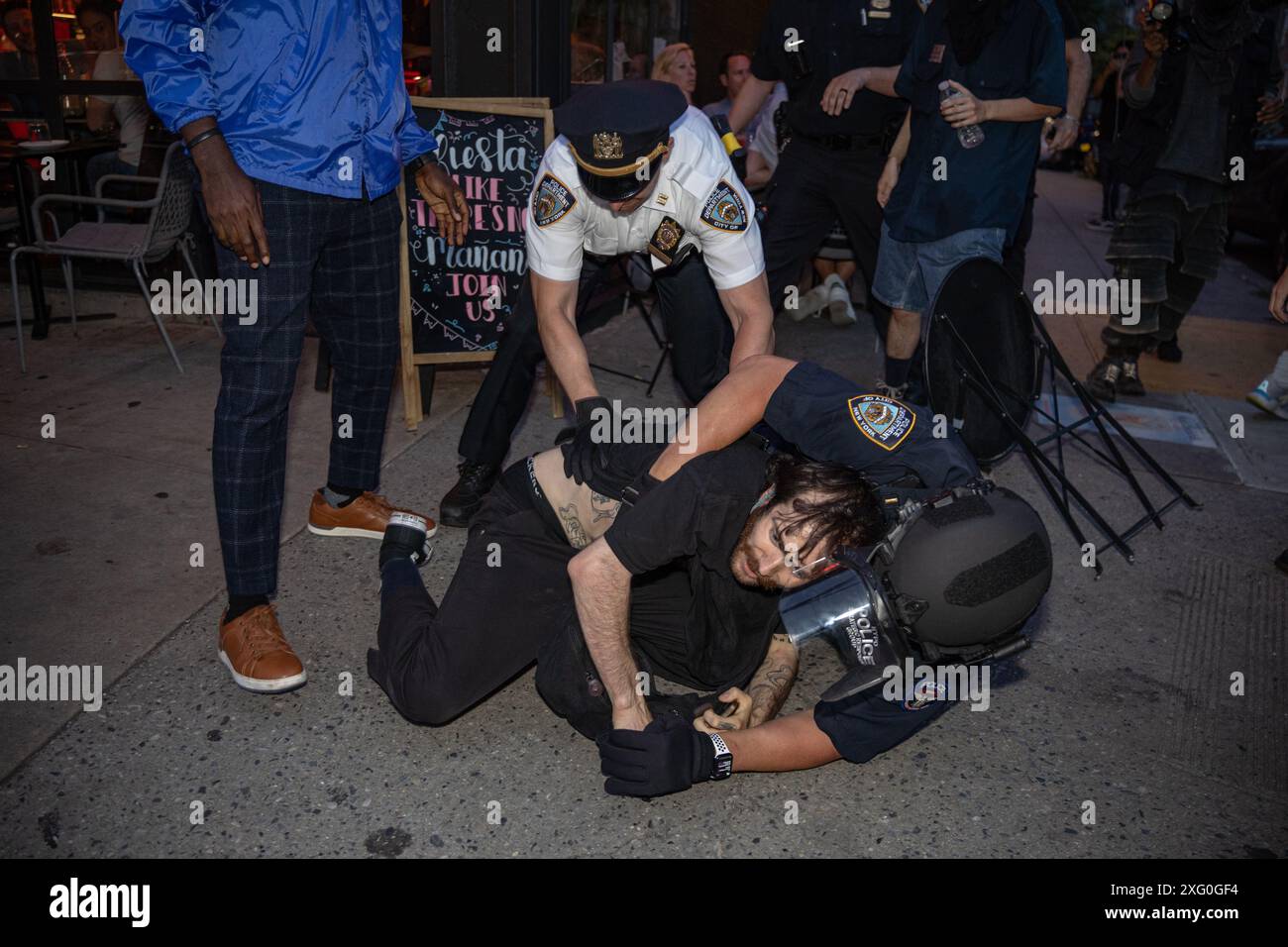 Manhattan, Usa. Juli 2024. NYPD Captain und SRG Officer greifen einen pro-palästinensischen Demonstranten an, als die Gruppe während der 'Flood 4th for Palestine'-Rallye in New York City vom Washington Square Park nach Chelsea marschierte. Quelle: SOPA Images Limited/Alamy Live News Stockfoto