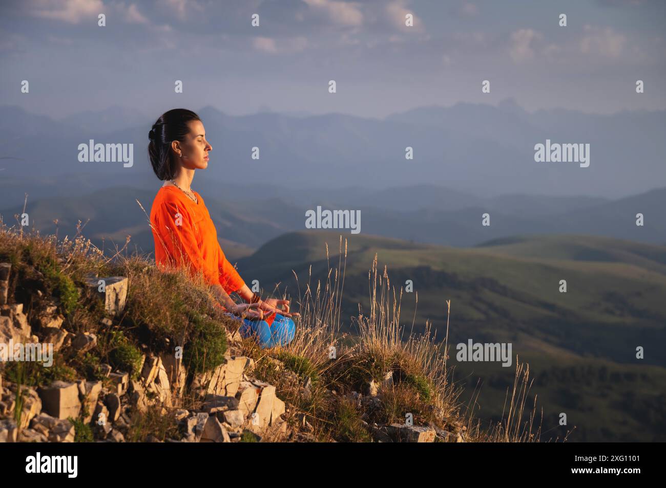 Meditierende Frau mit geschlossenen Augen in hellen Kleidern in den Bergen, Sportswear-Werbebanner Stockfoto