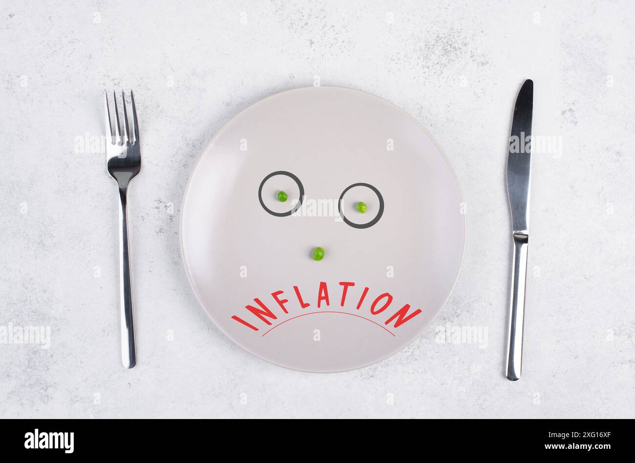 Inflation steht auf dem Teller, Nahrungsmittelknappheit und Hunger wegen Krieg, Hungersnot, politischer Frage, Angesicht mit grünen Erbsen Stockfoto