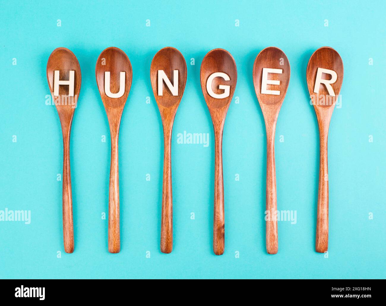 Hunger steht in deutscher Sprache auf den Holzlöffeln, Lebensmittelknappheit und Hunger wegen des Krieges und der Inflation, politische Frage Stockfoto Hunger steht in deutscher Sprache auf den Holzlöffeln, Lebensmittelknappheit und Hunger wegen des Krieges und der Inflation, politische Frage Stockfoto