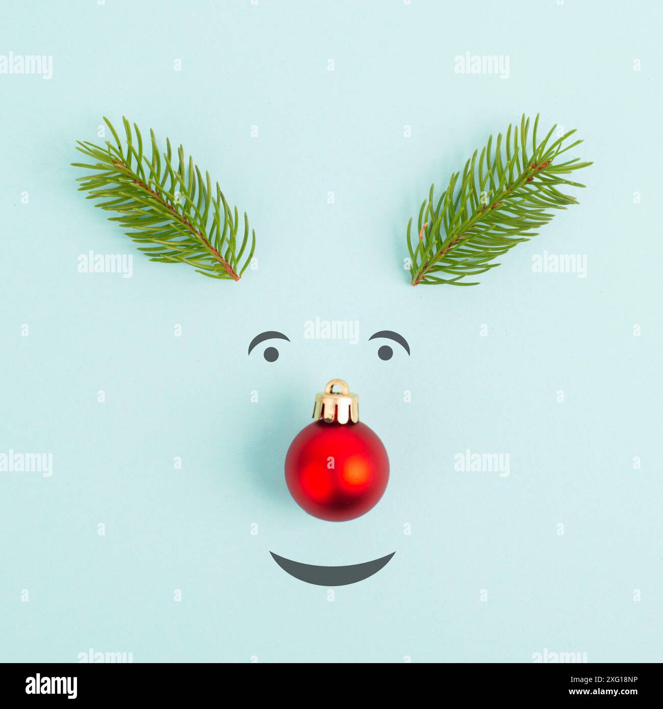 Gesicht eines Rentiers mit roter Kugelnase, Tannengeweih und freundlichen Augen, fröhliche weihnachtskarte Stockfoto