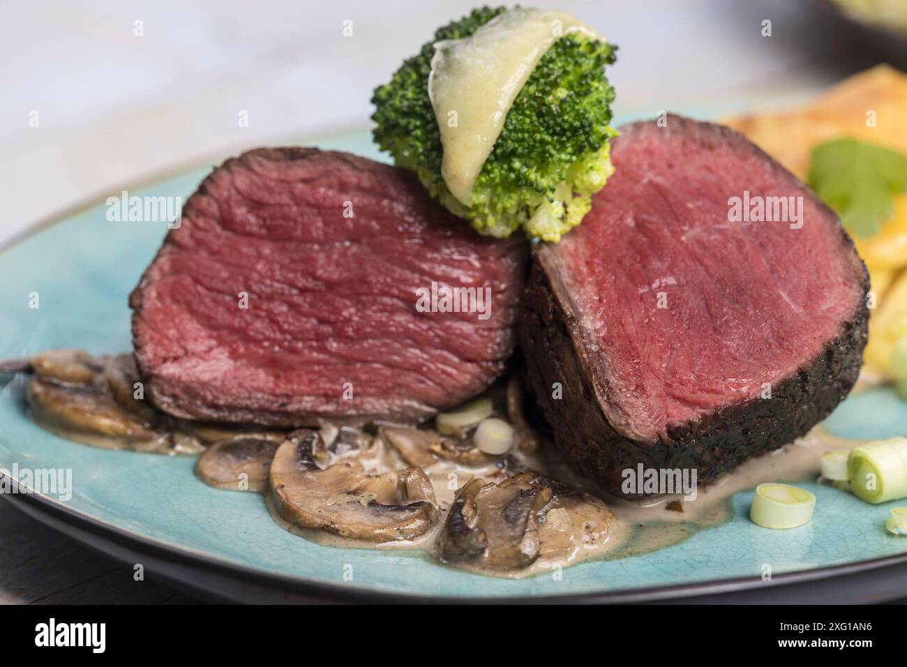 Geschnittenes Steak und Kartoffelgratin auf einem Teller Stockfoto