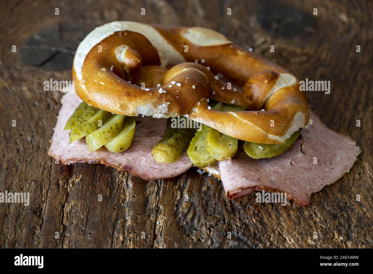 Leberkaese in Brezel auf Holz Stockfoto