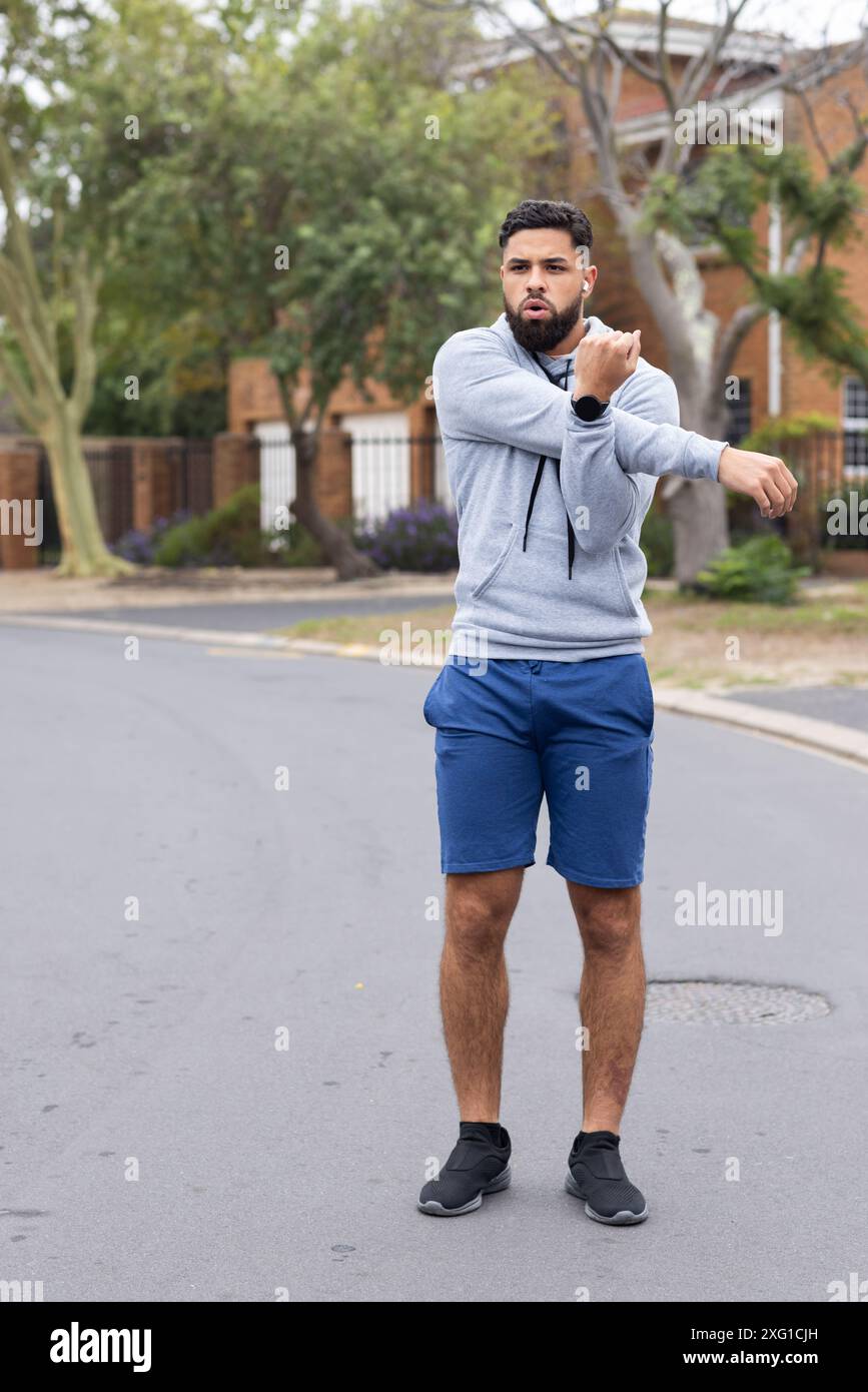 Sich draußen ausdehnen, Mann in Sportkleidung, der sich auf den Lauf in der Nachbarschaft vorbereitet, Kopierraum Stockfoto