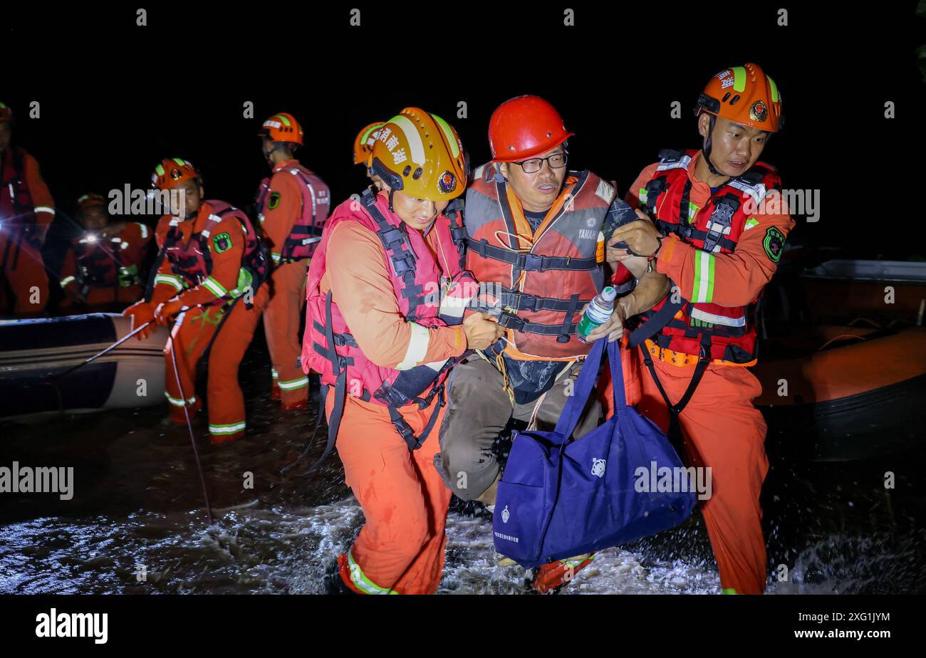 (240706) -- YUEYANG, 6. Juli 2024 (Xinhua) -- Retter bringen einen gestrandeten Bewohner in der Gemeinde Tuanzhou, County Huarong unter der Stadt Yueyang, zentralchinesische Provinz Hunan, 6. Juli 2024. Rettungskräfte, darunter Feuerwehrleute und bewaffnete Polizisten, überwachen genau die Situation eines Deichbruchs im Dongting Lake in der zentralchinesischen Provinz Hunan, der am Freitagnachmittag stattfand, sagten die lokalen Behörden. Die Bresche war ursprünglich etwa 10 Meter breit, hat sich seitdem jedoch weiter ausgebreitet. Die Verlegung von ca. 5.000 Bewohnern des betroffenen Bereichs wurde nach Angaben des örtlichen Unternehmens abgeschlossen Stockfoto