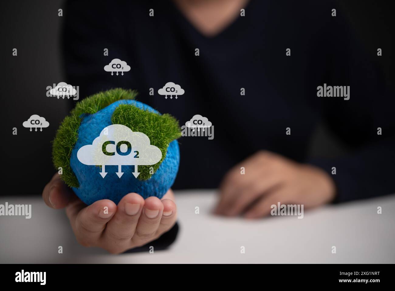 Hand mit grünem Globus mit CO2-Wolken. Visuelle Darstellung von Umweltthemen, Klimawandel und CO2-Emissionen. Ideal für Nachhaltigkeit Stockfoto