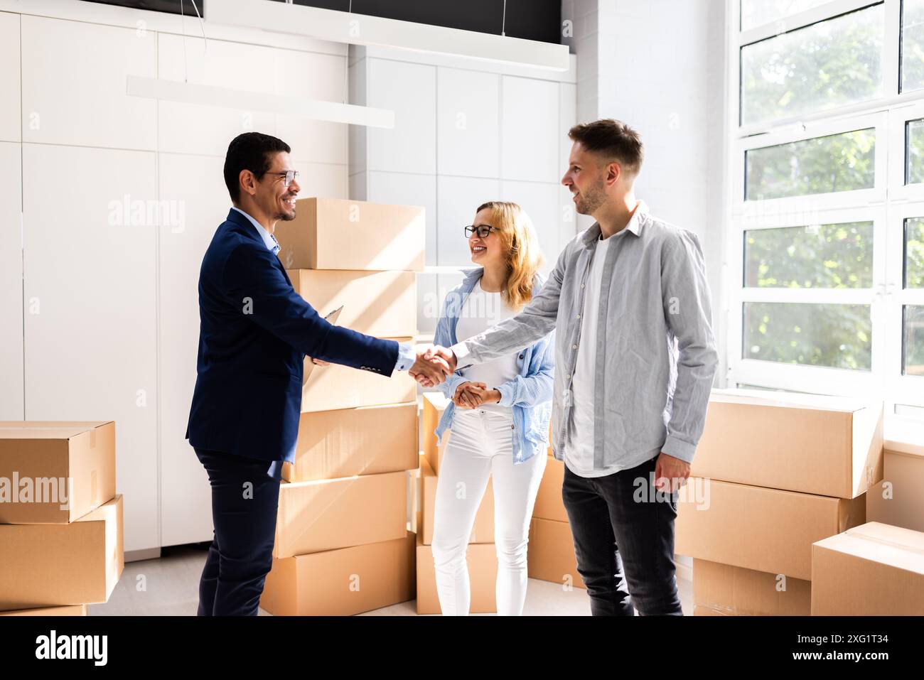 Glückliches Paar feiert den Abschluss des Geschäftsvorhabens mit Immobilienmaklern bei der Feier des neuen Immobilieneigentums Stockfoto