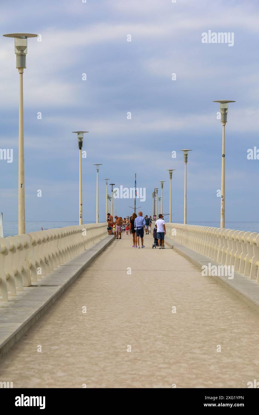 Seebahn mit Menschen in Forte Dei Marmi, einer italienischen Küstenstadt in der Provinz Lucca, im Norden der Toskana, mit Blick auf das Ligurische Meer. Stockfoto