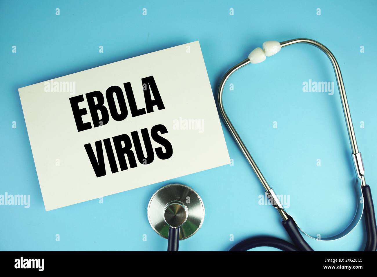 Ebola Virus Text auf Papier Karte mit Stethoskop Draufsicht auf blauem Hintergrund Stockfoto