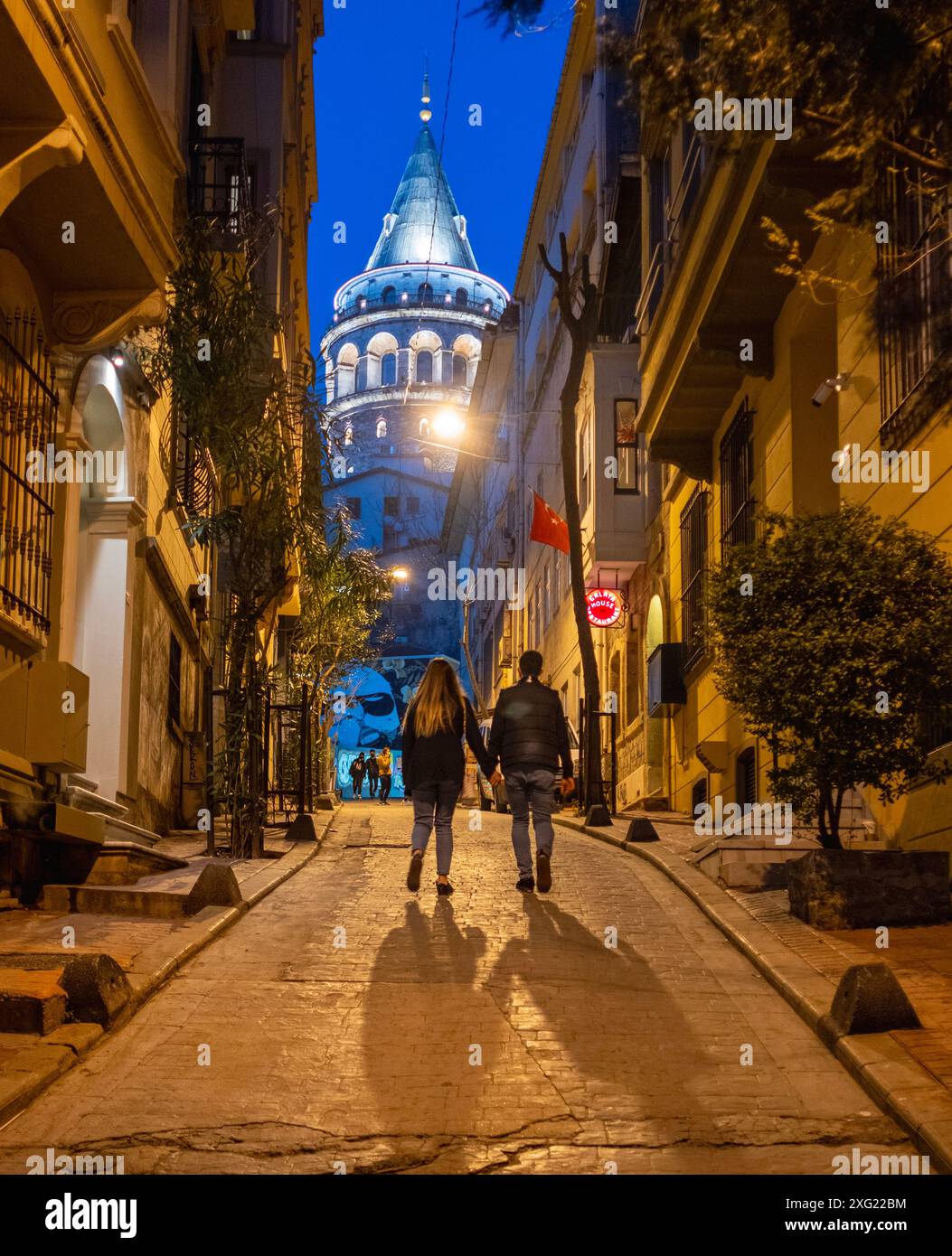 İstanbul, Türkei, 05.03.2021: Liebende halten Hände auf der Straße. Schattenspiele. Galata Tower, eines der berühmtesten Symbole von Istanbul. Stockfoto