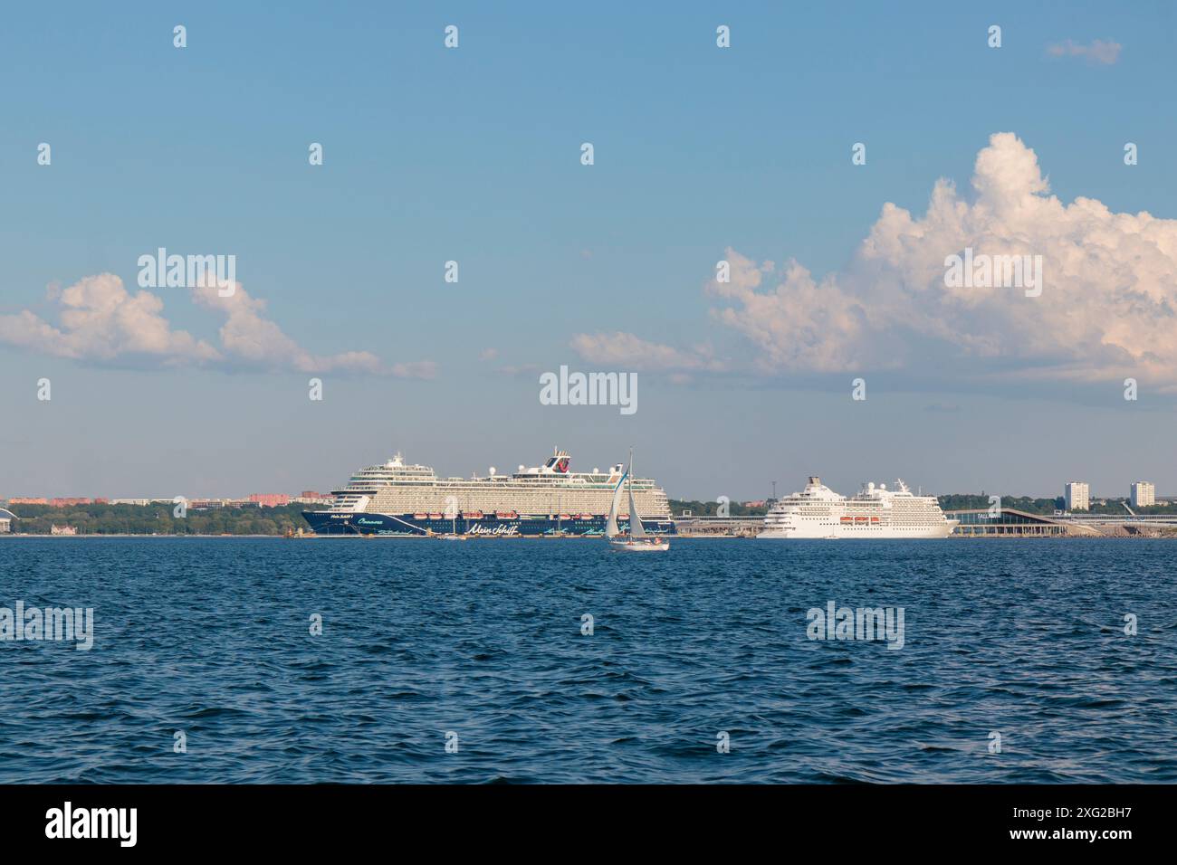 Golf von Finnland, Estland, 30. Juni 2024 - Fährhafen Tallinn mit Kreuzfahrtschiffen auf dem Dock mit Stadt Tallinn im Hintergrund bei sonnigem Wetter Stockfoto