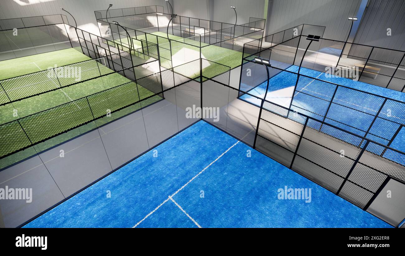 Aus der Vogelperspektive auf leere grüne und blaue Padel-Tennisplätze in einem Lagergebäude, das sich im Sportkomplex befindet. Mit Beleuchtungsbefestigung Stockfoto