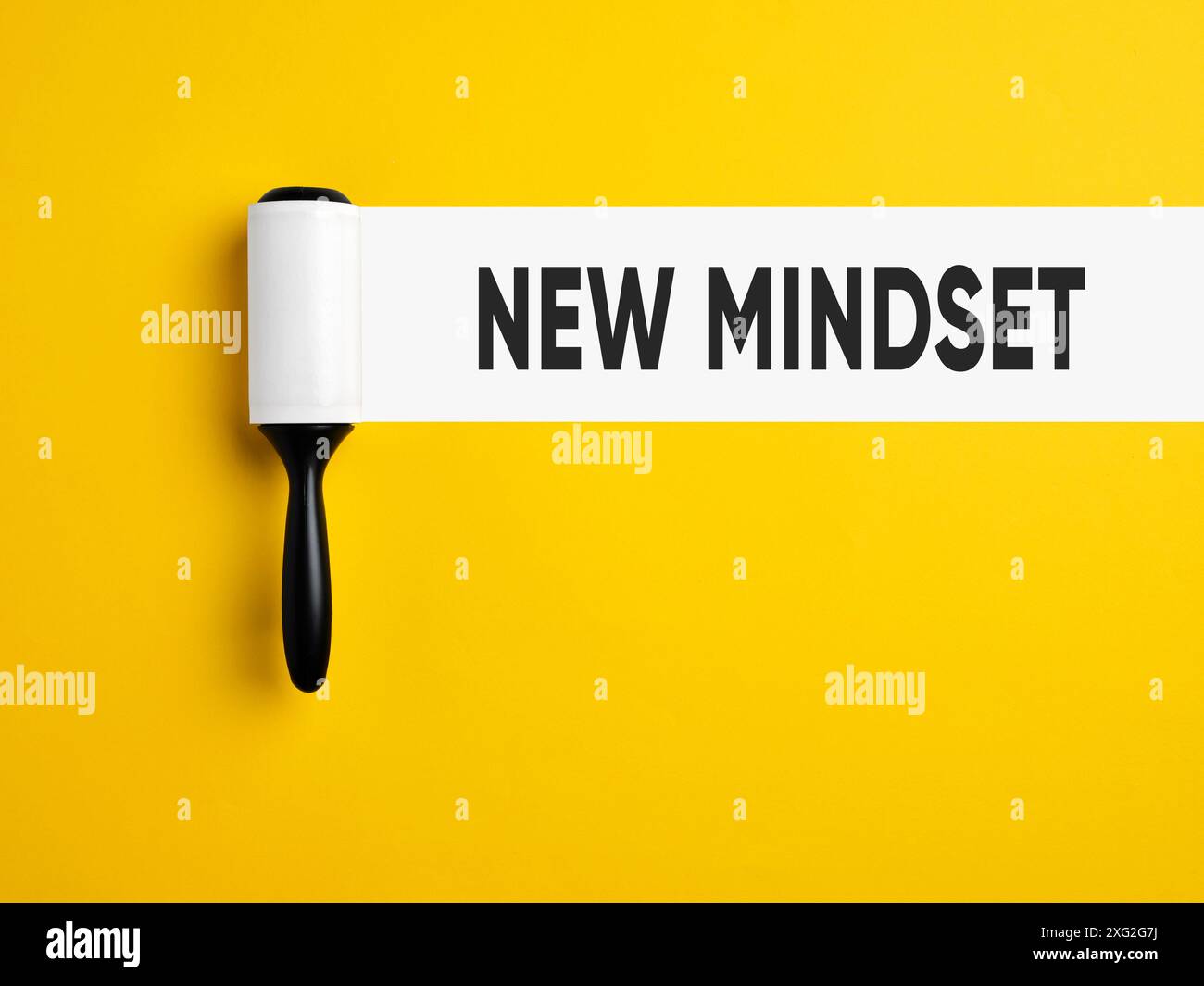 Neue Denkweise. Neue Perspektiven und neue Denkweisen. Fusselrolle mit weißer Spur auf gelbem Hintergrund mit der Botschaft New Mindset. Stockfoto