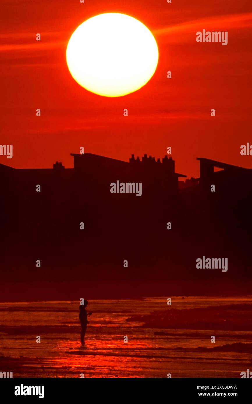 Isle Of Palms, Usa. Juli 2024. Am 6. Juli 2024 in Isle of Palms, South Carolina, steht eine Person, die von der aufgehenden Sonne umgeben ist. Eine brutale Hitzewelle treibt den Süden bis in die 90er Jahre Quelle: Richard Ellis/Richard Ellis/Alamy Live News Stockfoto