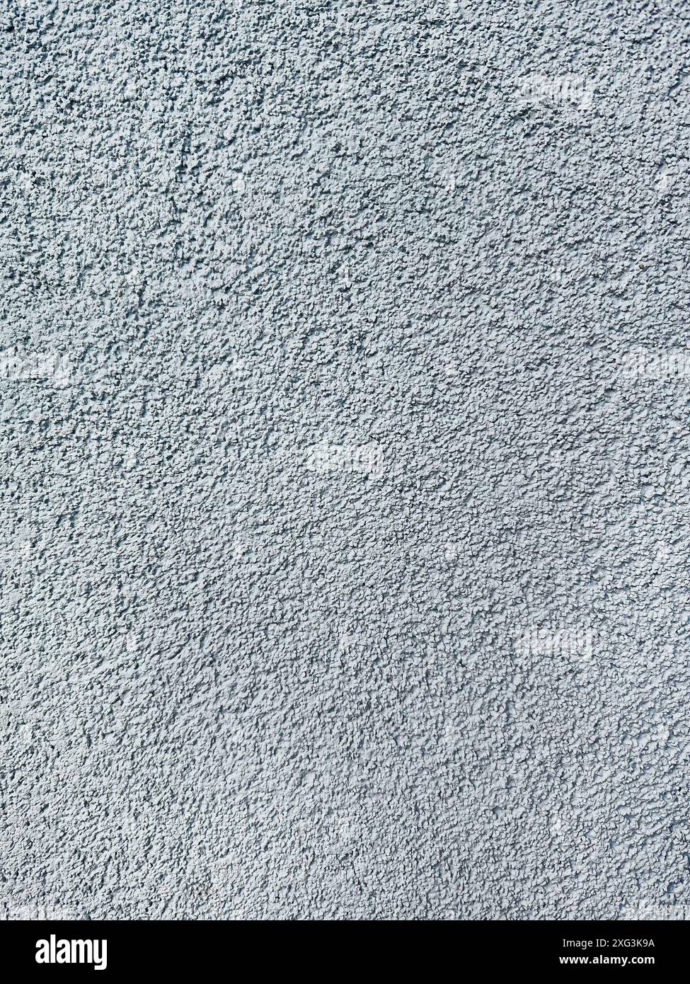 Nahaufnahme einer rauen, grauen Oberfläche, die an Beton oder Stuck erinnert. Die körnige Qualität und die ungleichmäßige Schattierung machen es geeignet für Stockfoto