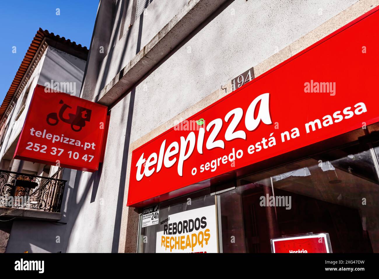 Telepizza-Ladenschild und Schindel zeigen den Roller-Lieferservice. Markenzeichen, Logo oder Symbol. Franchise Telepizza Fast-Food-Pizzarestaurant. Stockfoto