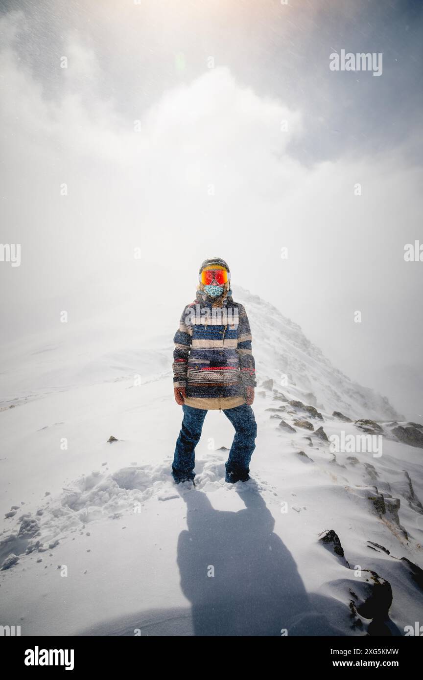 Porträt einer hübschen und aktiven Skifahrerin, die eine Maske trägt, aktive Winterferien. Extreme Lifestyle-Konzept Stockfoto