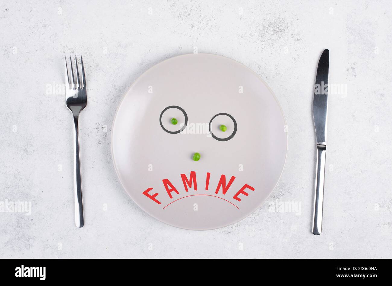 Hungersnot steht auf dem Teller, Lebensmittelknappheit und Hungersnot wegen des Krieges und der Inflation, politische Frage, mit grünen Erbsen konfrontiert Stockfoto