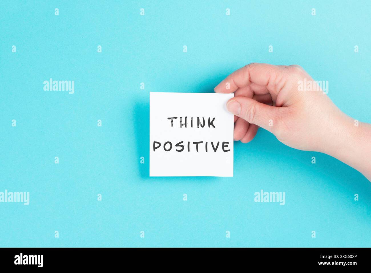 Die Worte „positiv denken“ stehen auf einem Papier, optimistische Denkweise, Coaching- und Motivationskonzept, Einstellung für den Erfolg Stockfoto