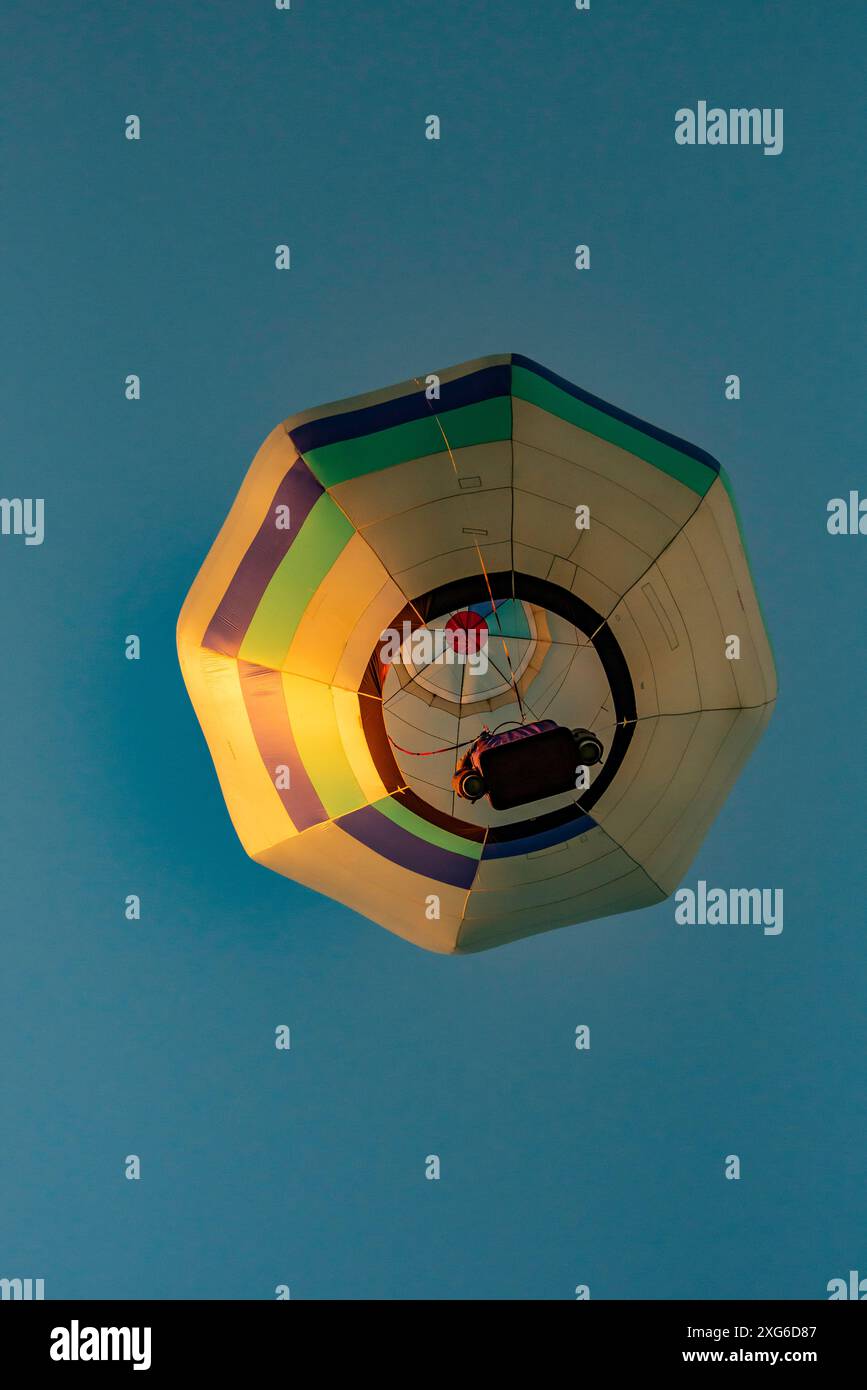 Von unten geschossen, steigt ein einzelner achteckiger Heißluftballon beim 2024 Ballons Over Waikato Festival in Hamilton auf der Nordinsel Neuseelands Stockfoto
