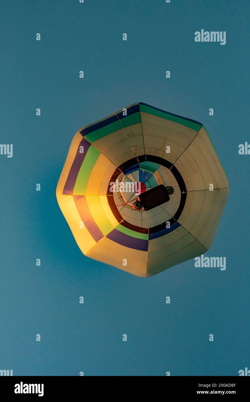 Von unten geschossen, steigt ein einzelner achteckiger Heißluftballon beim 2024 Ballons Over Waikato Festival in Hamilton auf der Nordinsel Neuseelands Stockfoto