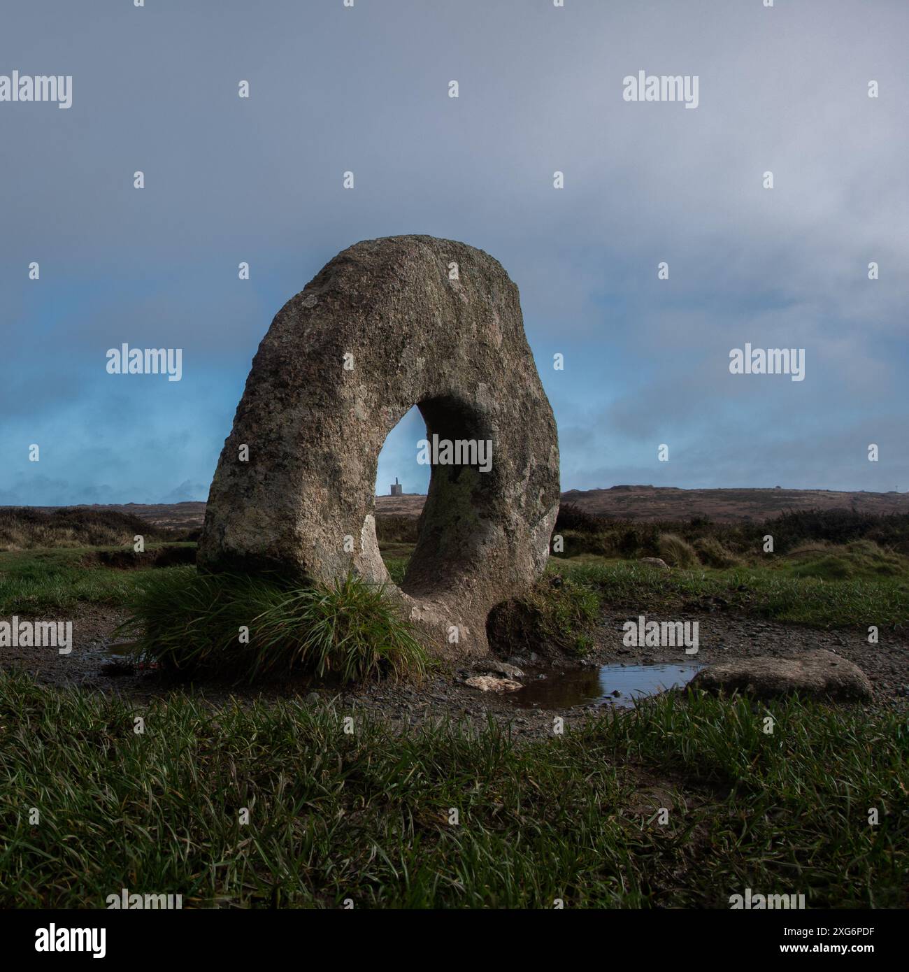 Ein Blick auf das kornische Moorland auf den Mên-an-Tol-Stein mit Greenburrow Engine House in der Mitte des Lochs in der Ferne. Stockfoto