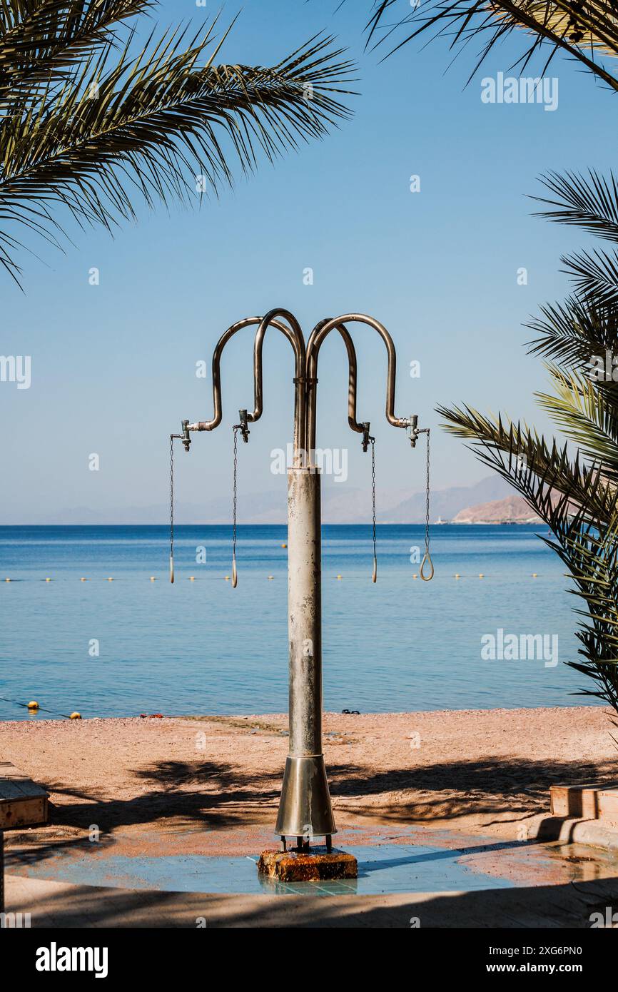 Öffentliche Freiluftdusche am Strand in Eilat, Israel. Rotes Meer im Hintergrund. Wunderschöne Aussicht. Erfrischende Körper nach Salzwasser Stockfoto