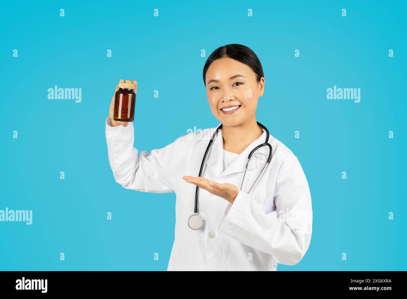 Lächelnde Ärztin Hält Medikamentenflasche Vor Blauem Hintergrund Stockfoto