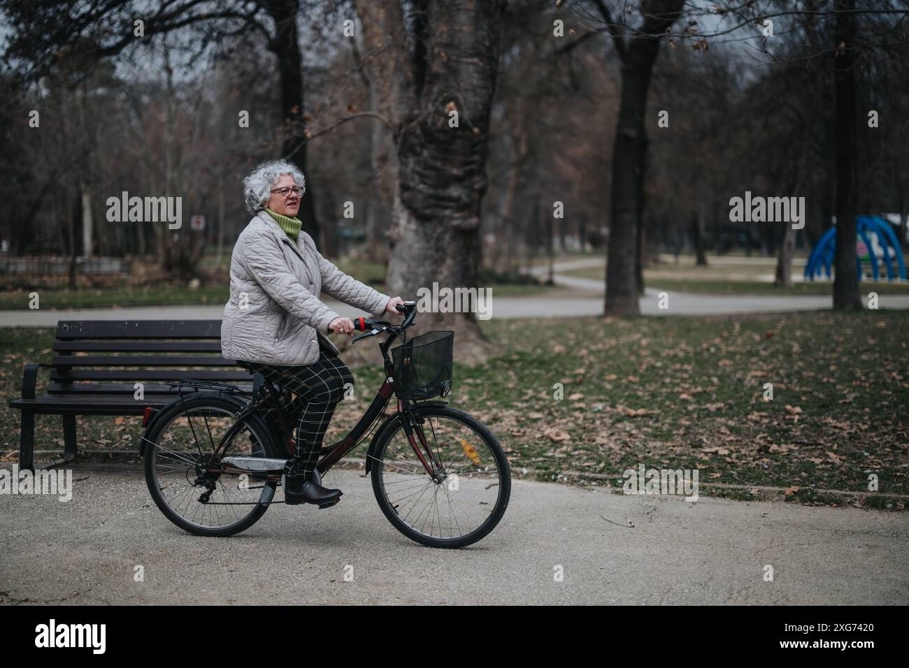 Aktive Seniorin, die eine Fahrradtour im Park macht Stockfoto