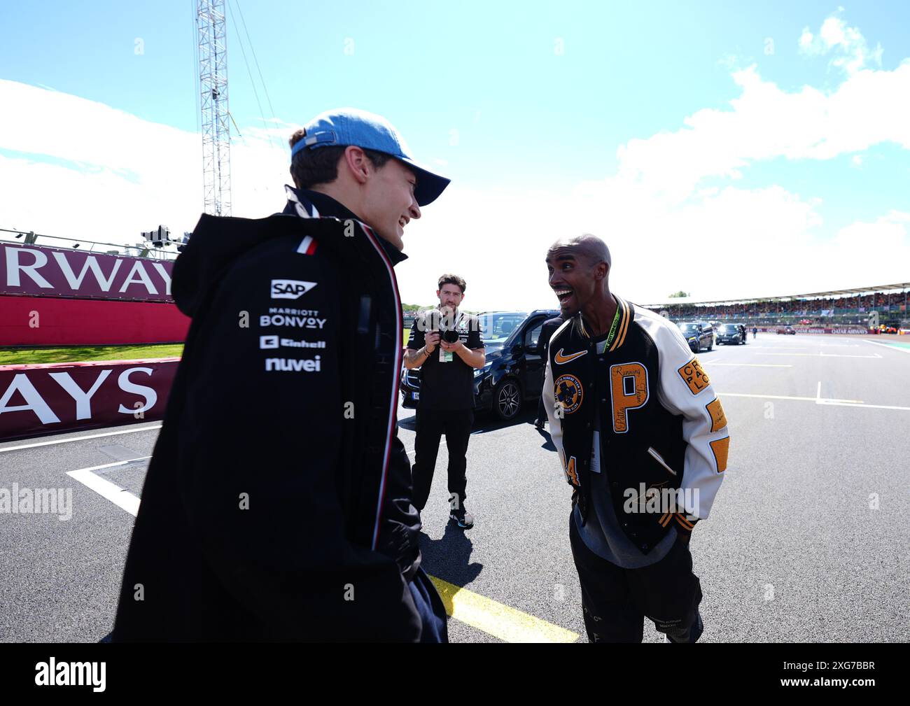 George Russell (links) und Sir Mo farah vor dem Rennen auf dem Silverstone Circuit in Northamptonshire. Bilddatum: Sonntag, 7. Juli 2024. Stockfoto