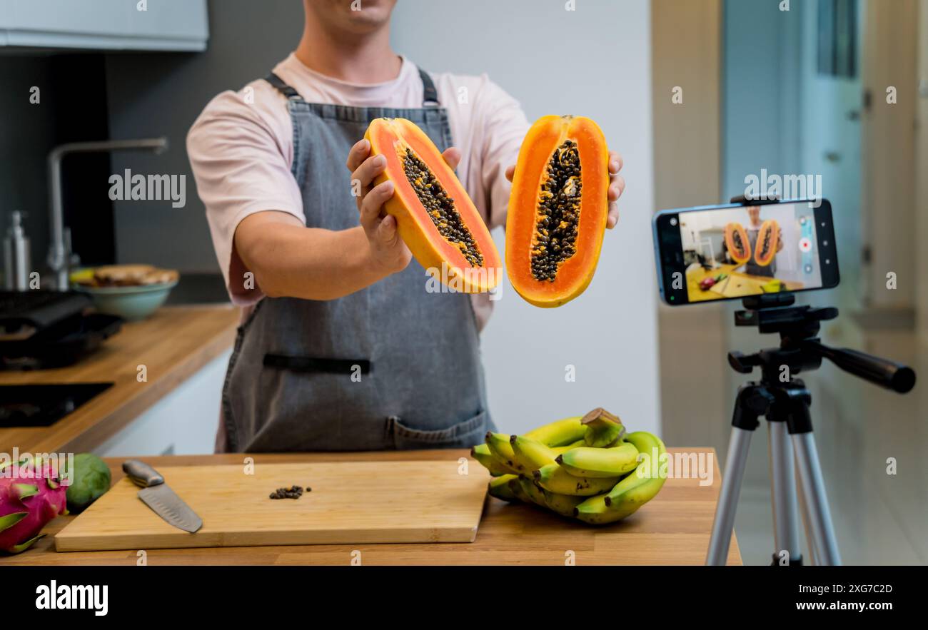 Der Koch sendet live aus dem Workshop, wie man Papaya schneidet und schält Stockfoto