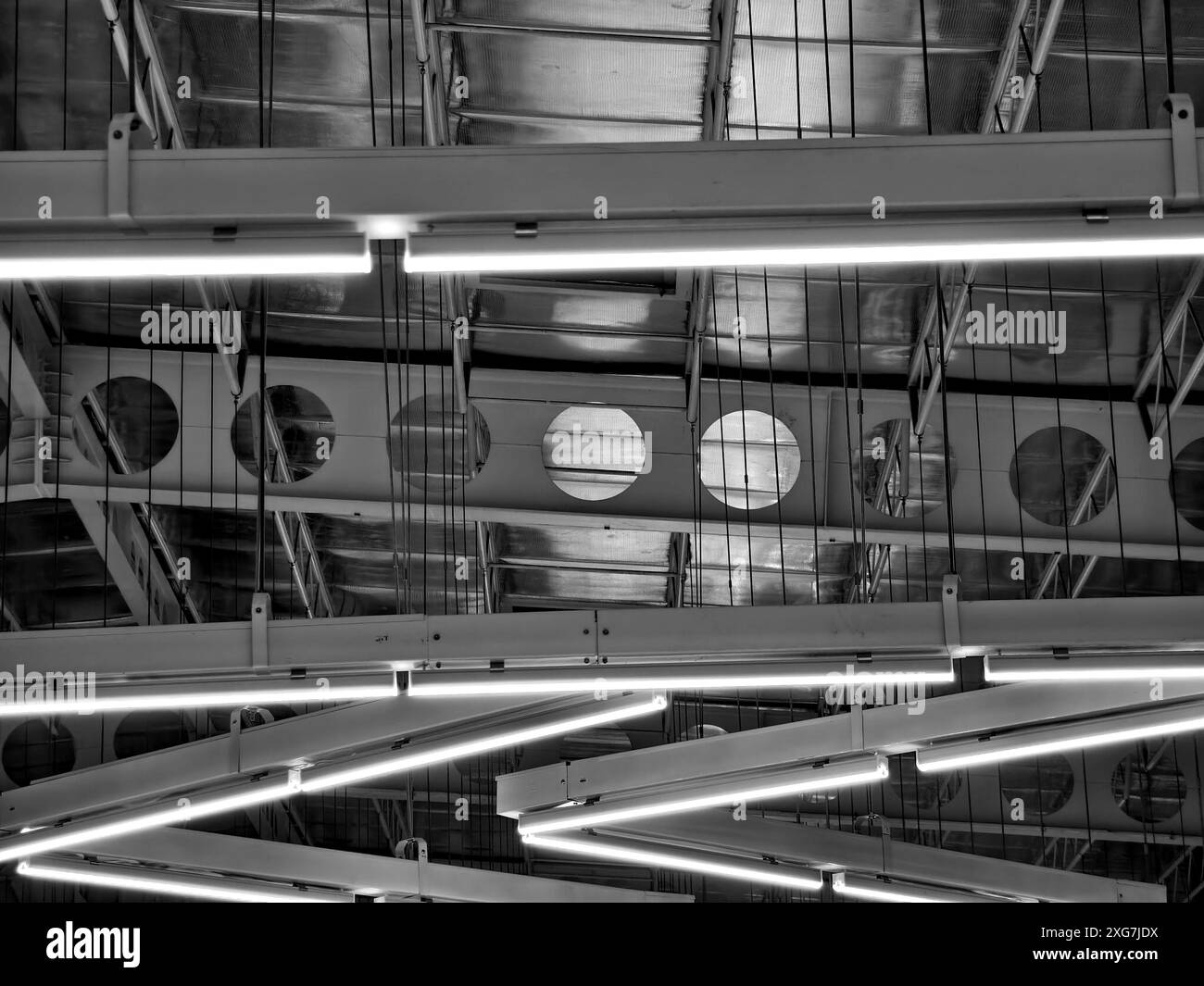 Die Decke mit Rohren ist wunderschön mit vielen Industrielampen dekoriert Stockfoto