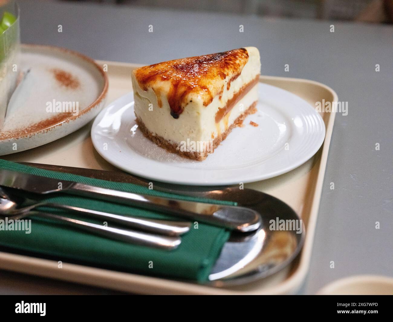 Käsekuchen auf einem weißen Teller mit Gabel oben auf dem weißen Tisch Stockfoto