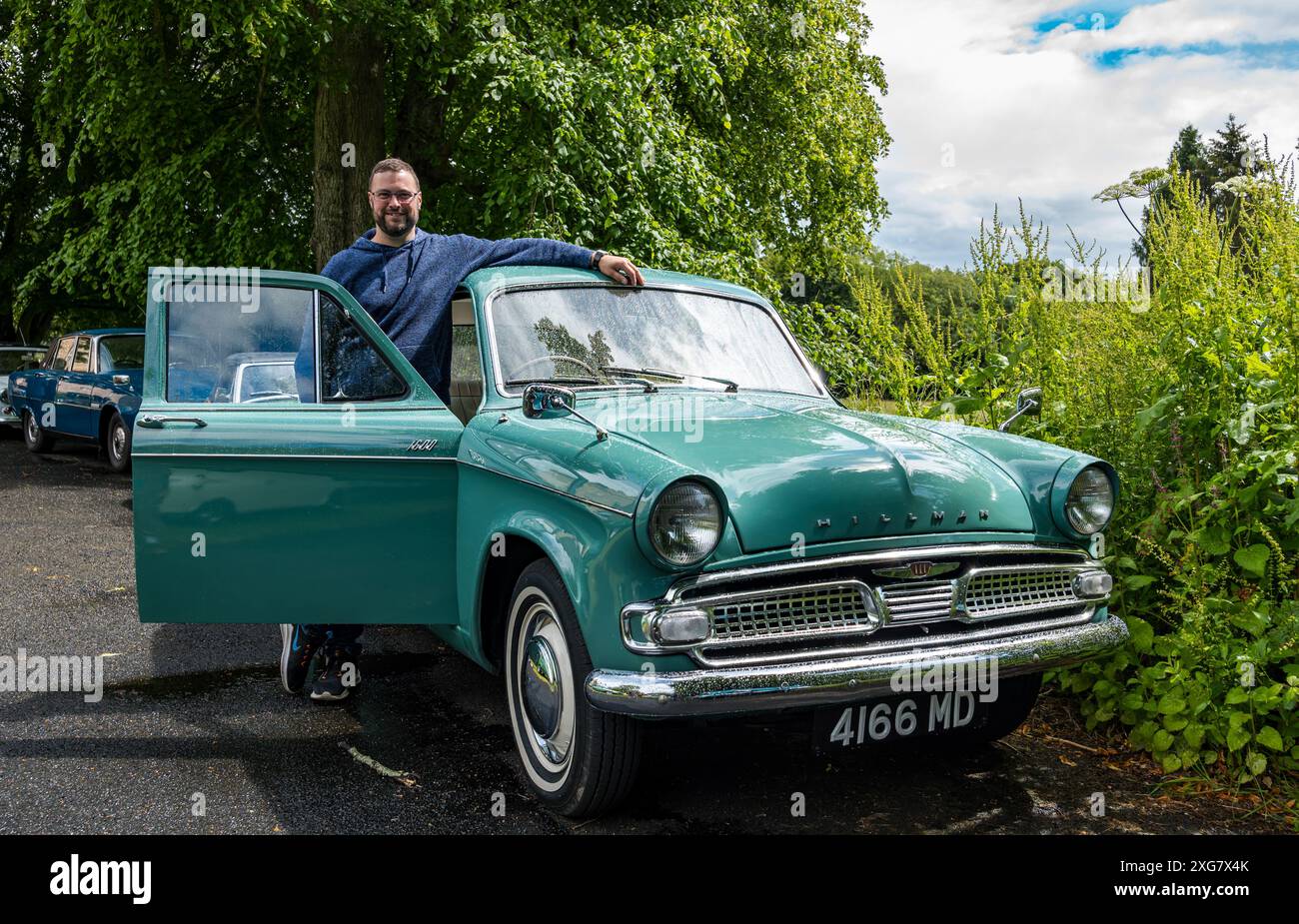 East Lothian, Schottland, Großbritannien, 7. Juli 2024. Räder der Vergangenheit: Die schottische Vereinigung der Fahrzeugliebhaber führt die Besitzer von Oldtimern durch die Landschaft zum malerischen Gelände von Lennoxlove. Im Bild: John Russell mit seinem makellosen Hillman Minx aus dem Jahr 1962. Quelle: Sally Anderson/Alamy Live News Stockfoto
