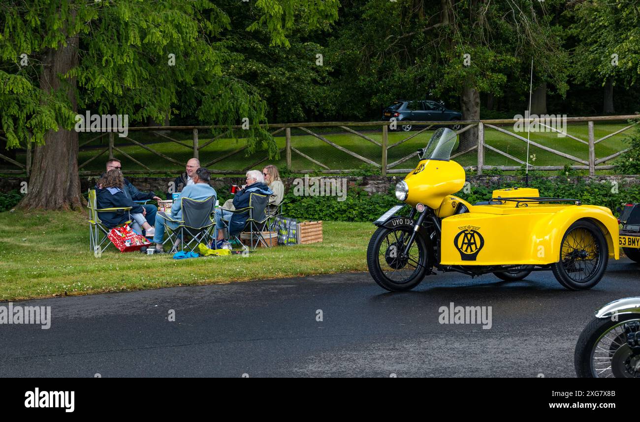 East Lothian, Schottland, Großbritannien, 7. Juli 2024. Räder der Vergangenheit: Die schottische Vereinigung der Fahrzeugliebhaber führt die Besitzer von Oldtimern durch die Landschaft zum malerischen Gelände des Lennoxlove House. Im Bild: Leute, die ein Picknick neben einem 1958 BSA AA Patrol Motorrad machen. Quelle: Sally Anderson/Alamy Live News Stockfoto
