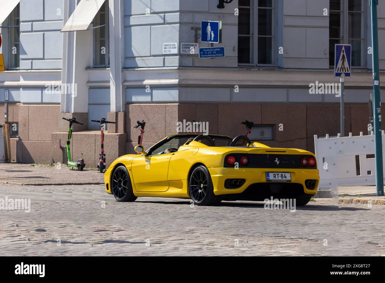 Ein gelber Ferrari fährt an einem Sommertag auf einer Kopfsteinpflasterstraße in der Innenstadt von Helsinki Stockfoto