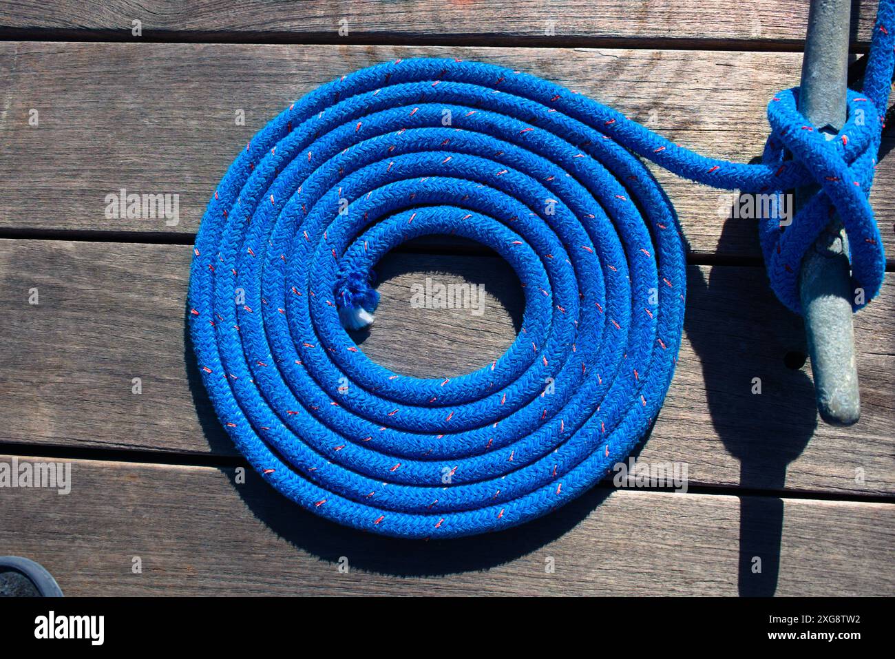 Gewickelte Dockinglinie neben einem Stollen an einem Yachthafen-Dock. Stockfoto