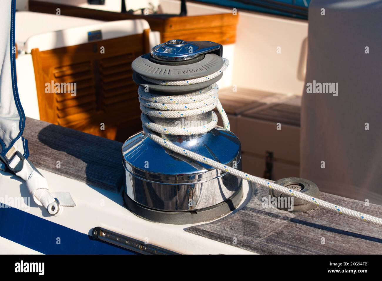 Eine Winde, die ein Segelboot benutzt, um die Segel einzustellen, mit einem weißen Seil um sie gewickelt. Stockfoto