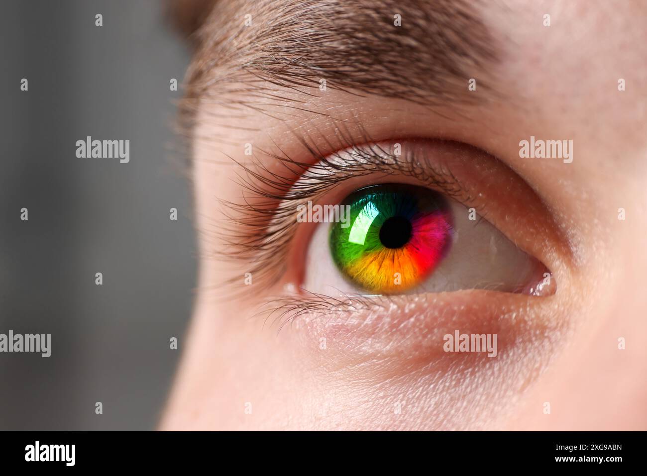 Das Auge des Mannes ist in Regenbogenfarben getönt, Nahaufnahme Stockfoto