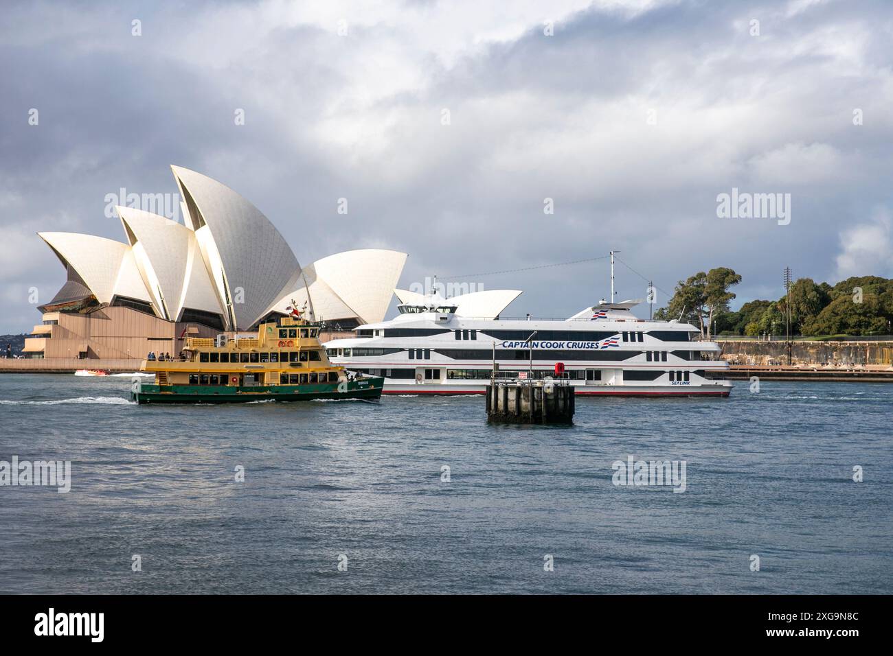 Sydney Opera House mit Sydney Fähre und Captain Cook Kreuzfahrt Schiff im Hafen von Sydney, New South Wales, Australien Stockfoto