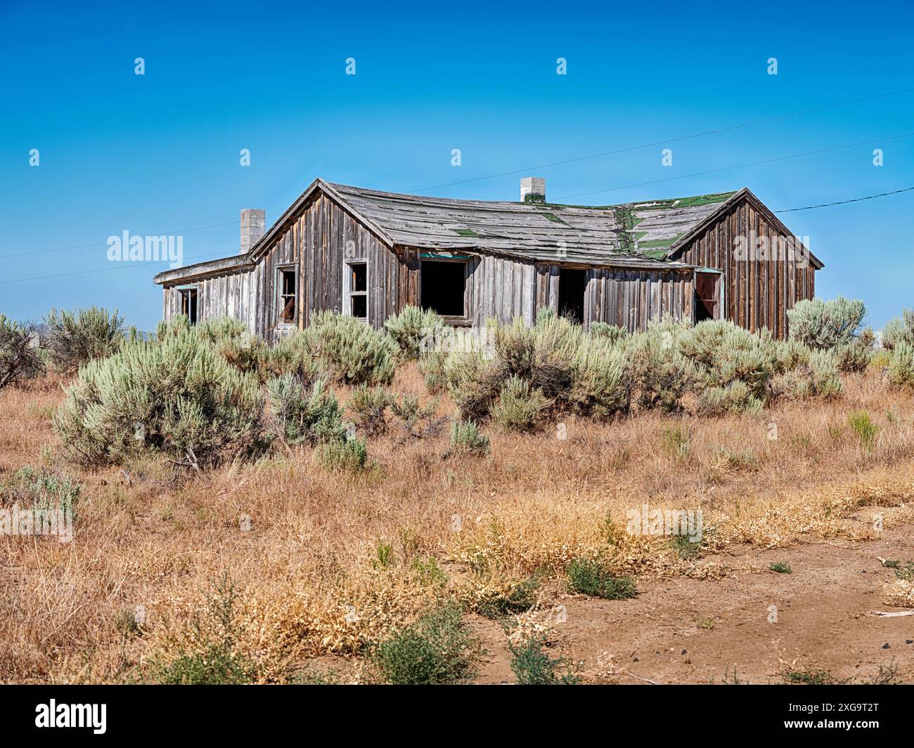 Ein verwittertes Gebäude auf einem alten Gehöft in der Nähe von Brogan, Oregon, wurde verlassen und verfällt langsam in der hohen Wüstenluft. Stockfoto