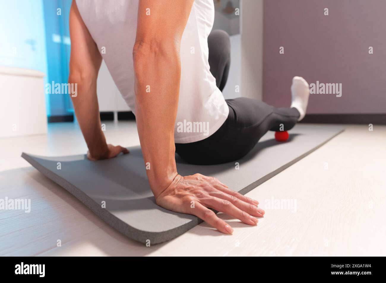 Kaukasische Frau, die myofasziale Fußmassage mit roter Massage macht. Myofasziale Freisetzung und Faszienarbeit Stockfoto