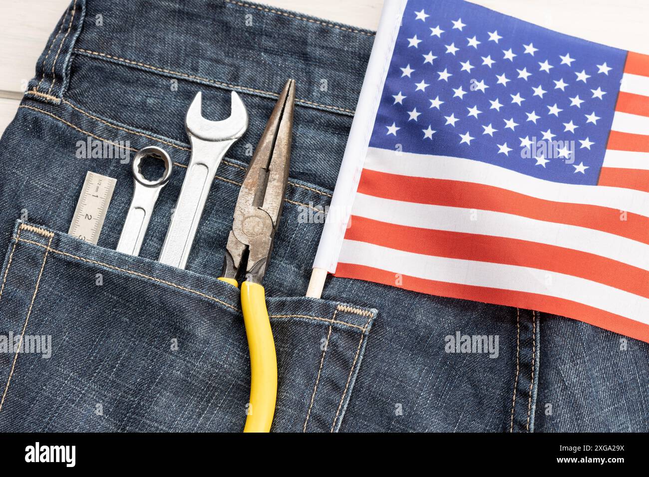 Set mit Werkzeugen und amerikanischer Flagge in Jeans-Tasche. Hintergrundkonzept für den Arbeitstag Stockfoto