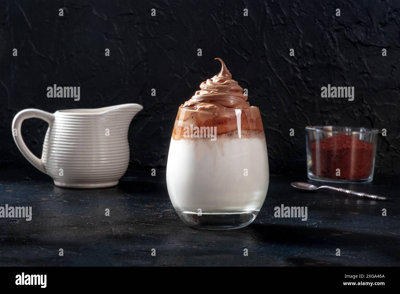Dalgona kalter Kaffee mit Zutaten und Platz für Kopien auf schwarzem Schiefergrund Stockfoto