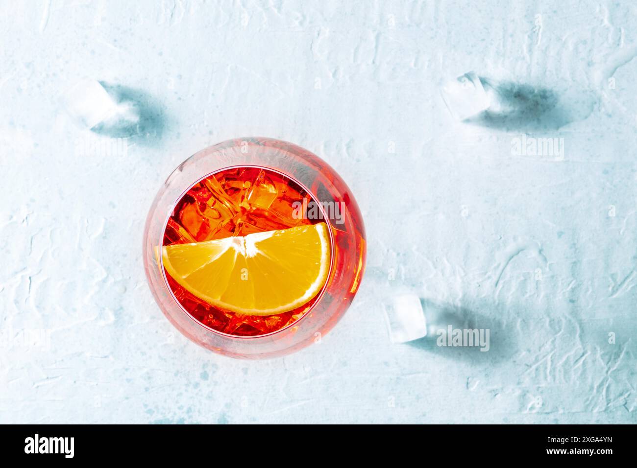 Aperol-Cocktail mit einer Orange und Eiswürfeln, italienisches sommerliches kaltes Getränk, von oben geschossen Stockfoto