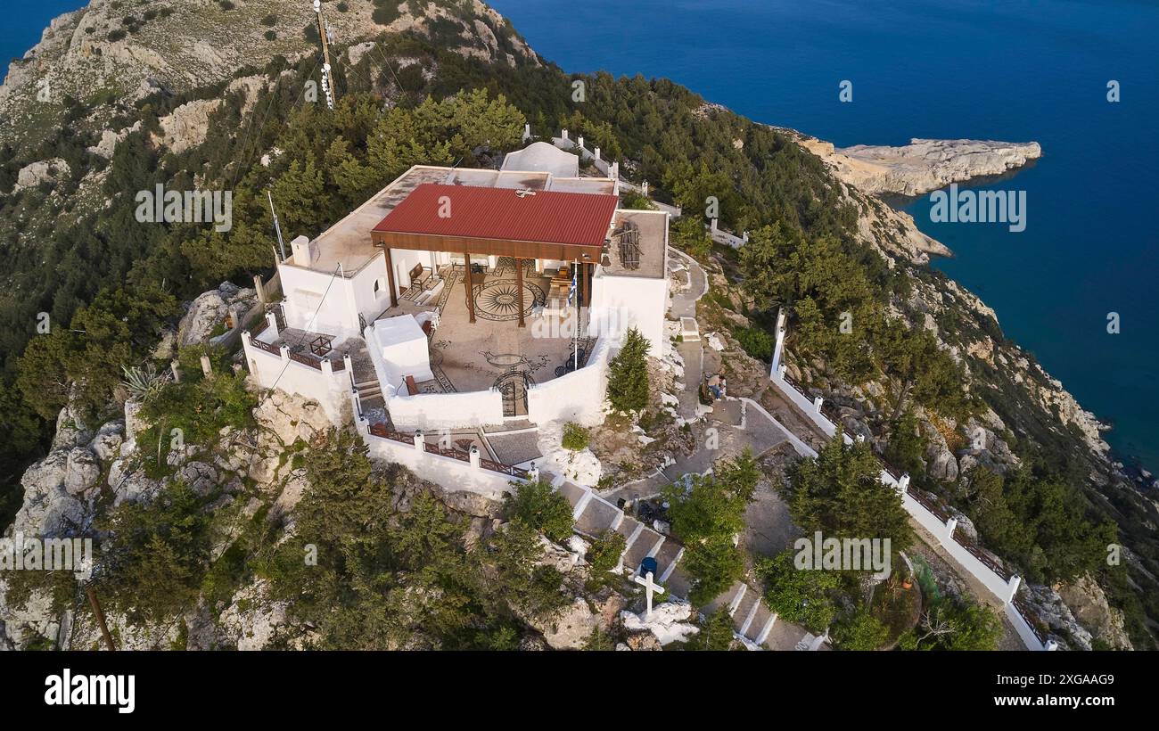 Drohnenaufnahme, Ein Gebäude mit einem roten Dach umgeben von Bäumen auf einem Hügel in der Nähe des Meeres, Panagia Kyra Kirche, über Tsambika Beach, Aussichtspunkt, Tsambika Stockfoto