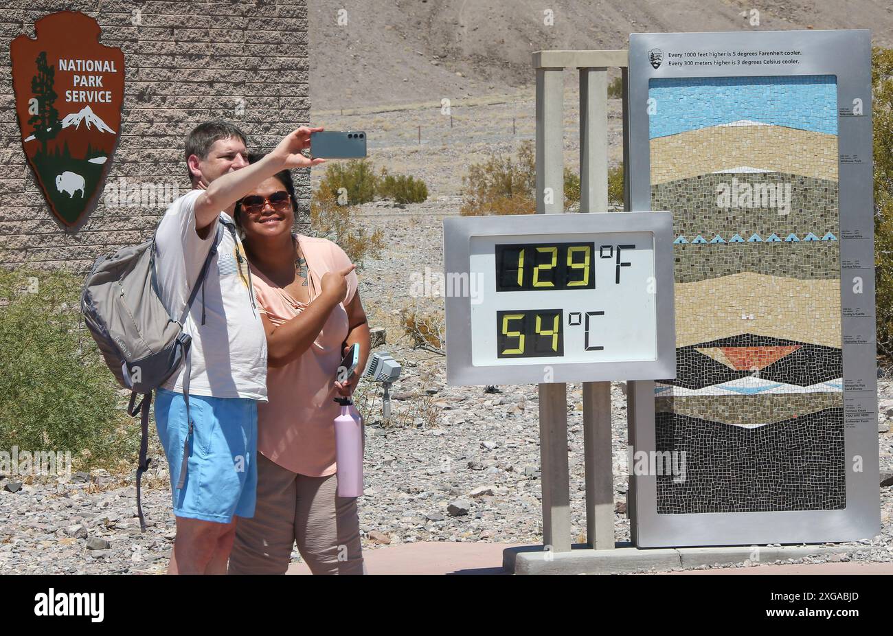 Death Valley, Usa. Juli 2024. Im Furnace Creek Visitor Center im Death Valley National Park machen Besucher ein Selfie mit einem inoffiziellen Thermometer, das 129 Grad Fahrenheit/54 Grad Celsius anzeigt. Quelle: SOPA Images Limited/Alamy Live News Stockfoto