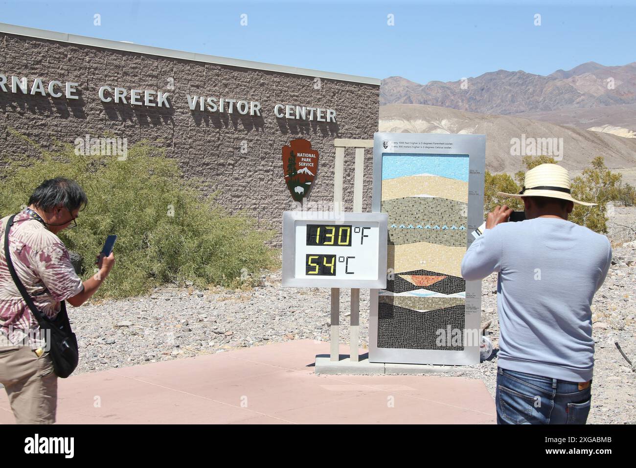 Death Valley, Usa. Juli 2024. Menschen posieren mit einem inoffiziellen Thermometer, das 130 Grad Fahrenheit/54 Grad Celsius im Furnace Creek Visitor Center im Death Valley National Park anzeigt. (Foto: Gabe Ginsberg/SOPA Images/SIPA USA) Credit: SIPA USA/Alamy Live News Stockfoto