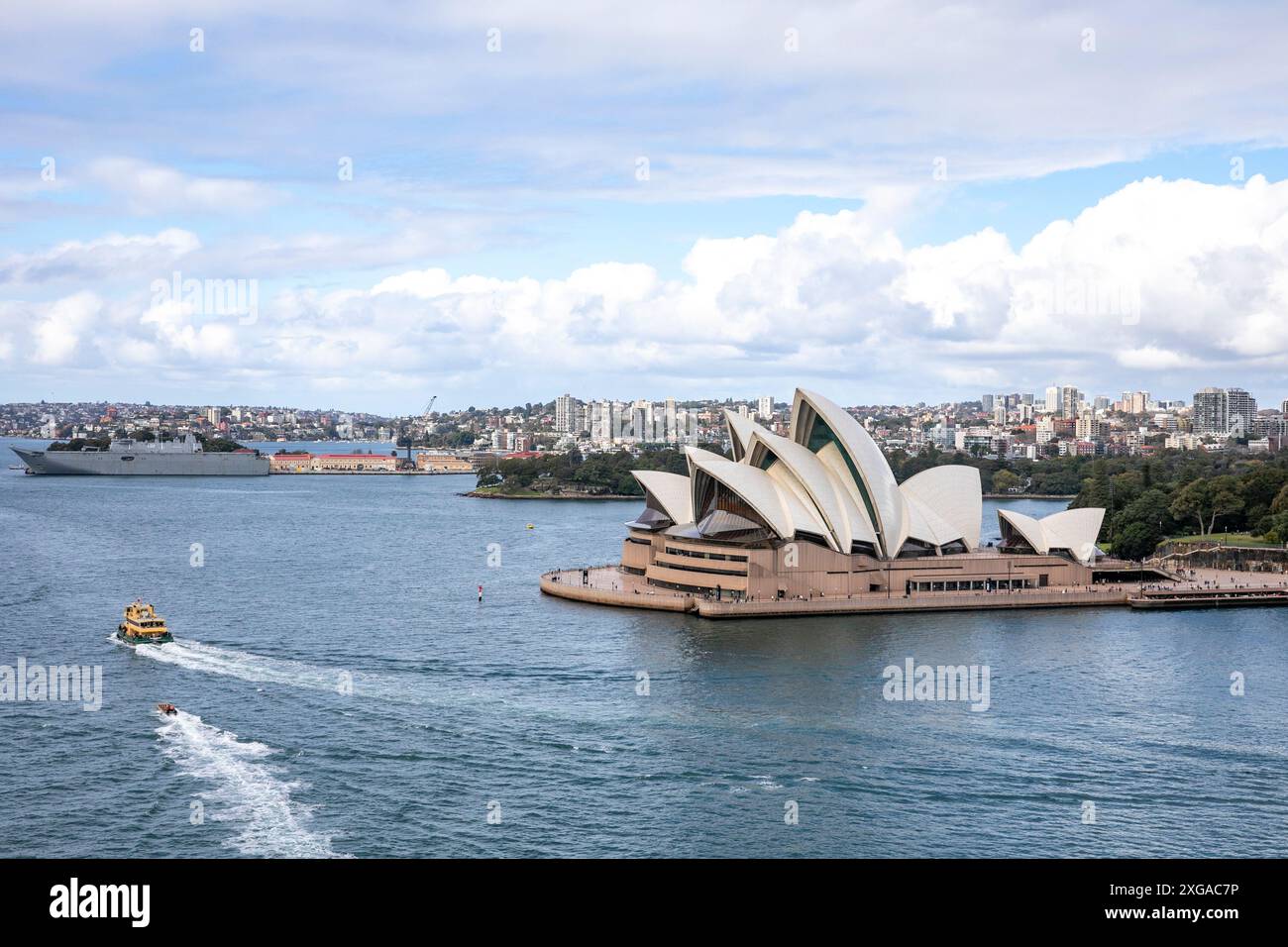 Hafen von Sydney, Royal Australian Naval Schiff HMAS Canberra in Garden Island und Sydney Opera House Gebäude, New South Wales, Australien Stockfoto