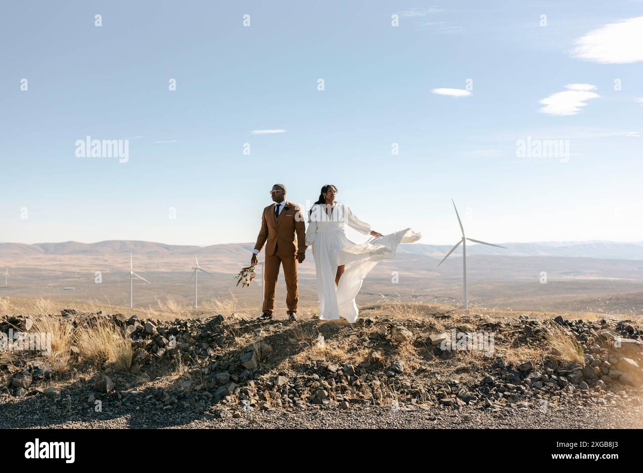 Ehemann und Ehefrau halten Hände an einer Solar-Windkraftanlage Stockfoto